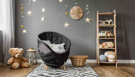 stylish scandinavian newborn baby room with toys children s chair natural basket with teddy bear and small shelf modern interior with grey background walls wooden parquet and stars patternの素材