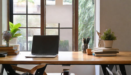 minimalist bright desk in co working office room with laptop and copy space on wooden tableの素材