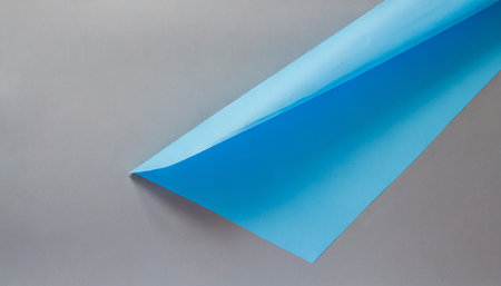 colored blue paper sheet on grey backgroundの素材