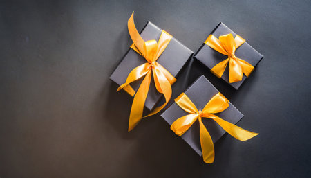 dark gift boxes with satin ribbon and bow on black background holiday gift with copy space birthday or christmas present flat lay top view christmas giftbox black friday conceptの素材