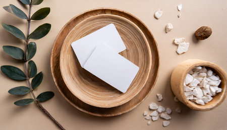 business cards on a wooden round plate on a beige background top view closeupの素材