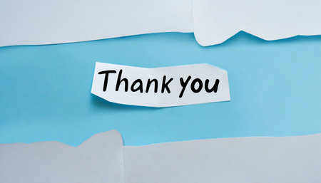 thank you text on white paper cut out over blue background gratitude conceptの素材