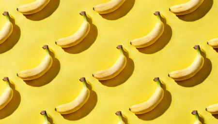 banana pattern on a yellow background exotic fruit repetition viewed from above top viewの素材