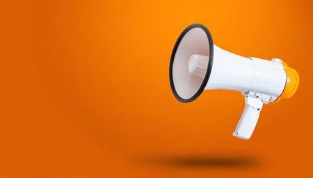 white megaphone or bullhorn floating over orange background business announcement or communication concept with copy spaceの素材
