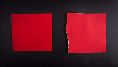 scraps of two red posters on a black backgroundの素材