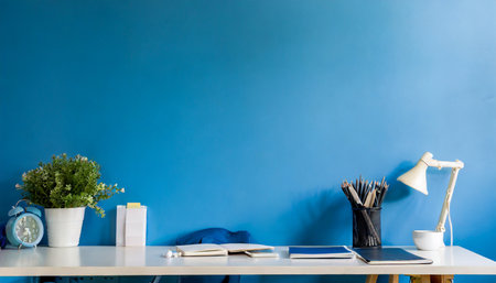 stylish blue room office setup desk with supplies and wall copy space for a minimalistic workspace modern blue room office designの素材