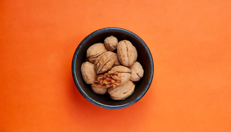 walnut bowl isolated on a orange background viewed from above top viewの素材