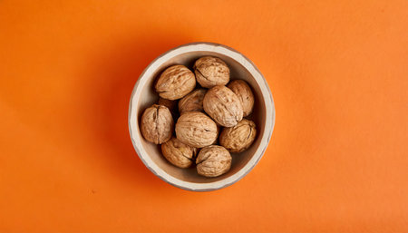 walnut bowl isolated on a orange background viewed from above top viewの素材
