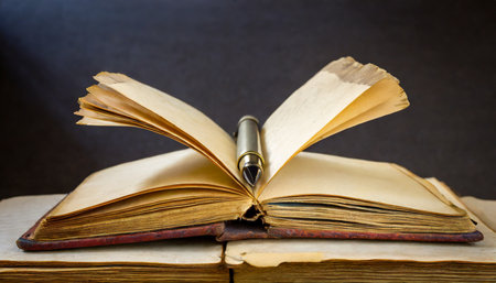 opened old book with aged pages with a pen between pagesの素材