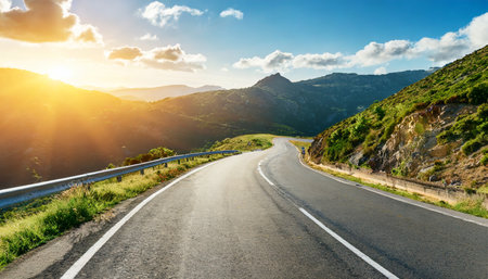 empty long mountain road to the horizon on a sunny summer day at bright sunsetの素材
