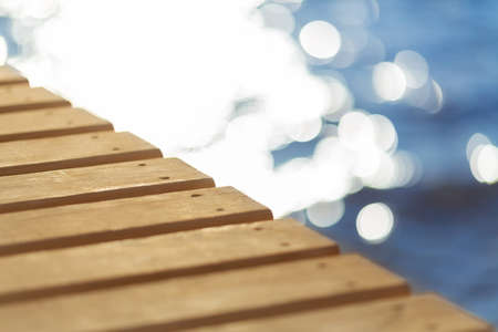 Wooden pier stretching into the blue sea. Shallow depth of fieldの写真素材