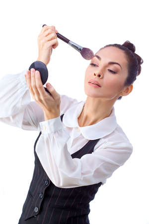 Beauty Girl with Makeup Brushes and Mirror. Natural Make-up for Brunette Woman with Brown Eyes. Beautiful Face. Makeover. Perfect Skin. Applying Makeupの写真素材