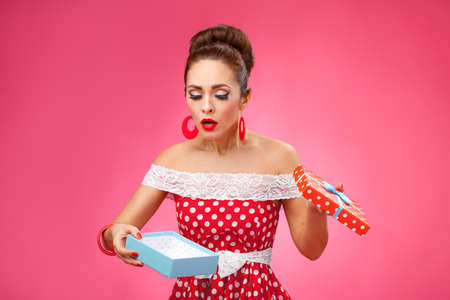 Woman disappointed gift, wearing red retro dressの写真素材