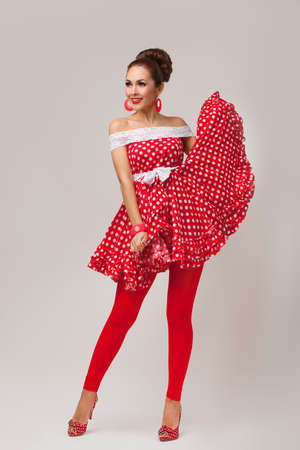 Funny portrait of a smiling cute young female model wearing red dressの写真素材