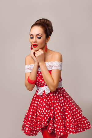 Funny portrait of a smiling cute young female model wearing red dressの写真素材