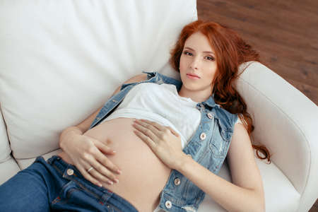 Young attractive pregnant woman relaxing on the sofaの写真素材