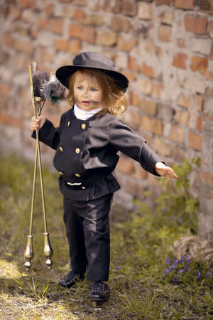 Girl as a chimney sweep against brick wall.の写真素材
