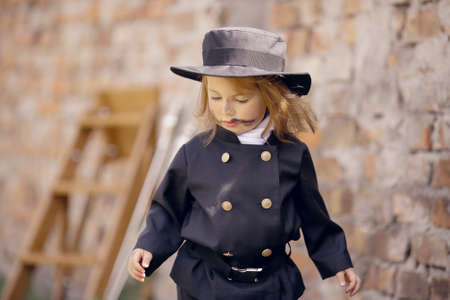Girl as a chimney sweep against brick wall.の写真素材