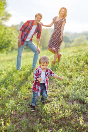 Kid enjoying holidays with his family in the park on a sunny summer day on the natureの写真素材