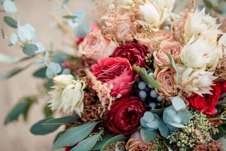 Beautiful wedding colorful bouquet for bride against nature background close-up macro shot. Beauty of colored flowers. Bridal accessories. Female decoration for girl. Details for marriage and for married coupleの写真素材