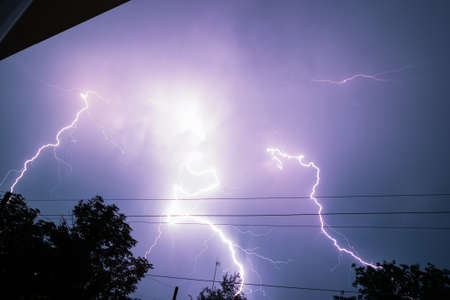 Real lightning bolt in city during a storm, seen from house window