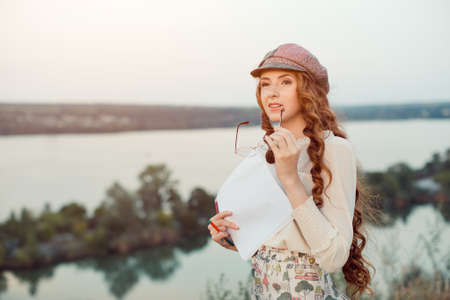 Woman writer concept. Student thinking and looking far afar standing on ashore on a slope. Joyful...