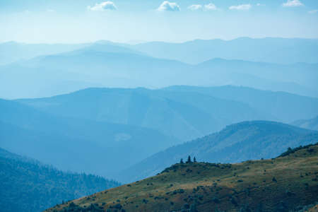 Abstract mountain background - concept of tourism and mountaineering. Layers of ridges in Carpathians Mountains Ukraine at sanrise skyの写真素材