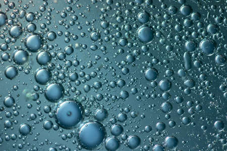 Abstract water bubbles light illumination background, macro art of water bubbles on water surface background display for your products and artwork design. Abstract glare on bubbles and watery backgroundの写真素材