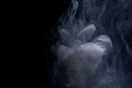 Abstract acrylic paint swirls in water on black backgroundの写真素材