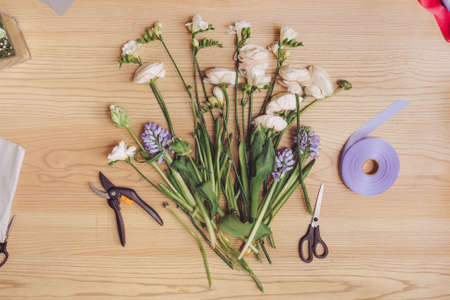 Beautiful flowers and florist equipment on wooden tableの写真素材