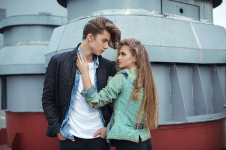 Fashion young couple in rock style hugging each other. Pretty girl and handsome man posing outdoors in city streetの写真素材