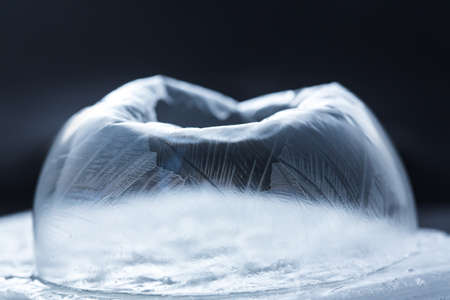 Frozen Snow Globe Snowflake Destructing. Ice patterns frosted on ball of soap collapsing against...