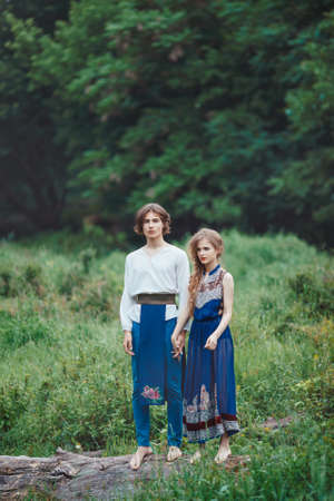 Young couple of elves in love standing in magical forest outdoor on nature. Dramatic romantic photo. Fairy tale love, relationship and magic people concept. Man and woman together pass vital testsの写真素材