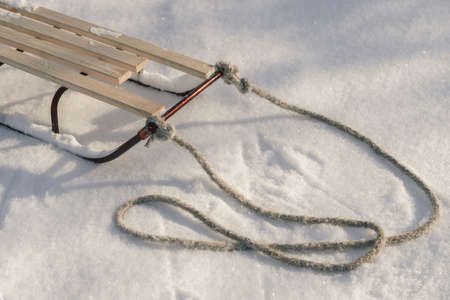 Sledge with rope in snow winter close-up shot. Good background with copy space for winter holidays concept banner.の写真素材