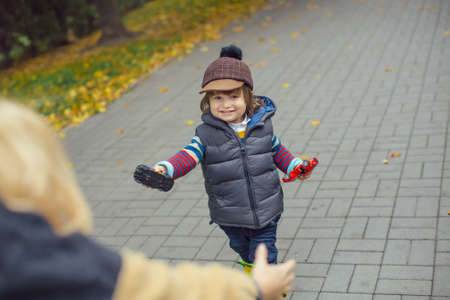 Cute cheerful child with mother play outdoors in the park