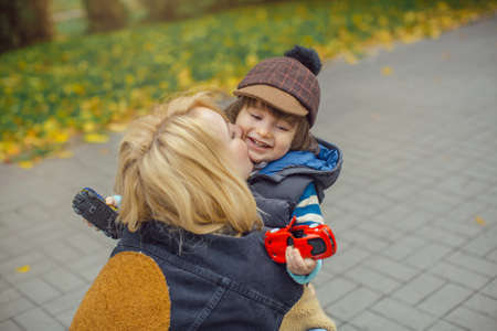 Cute cheerful child with mother play outdoors in the parkの写真素材