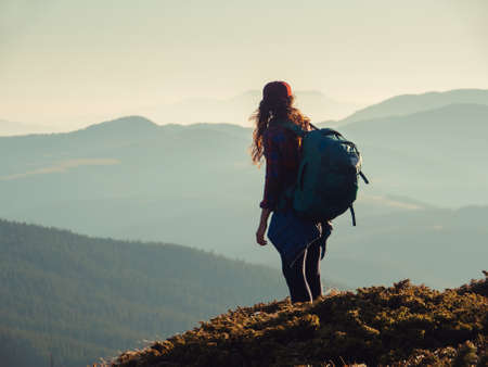 Hiker Woman with Backpack on Top of a Mountainの写真素材