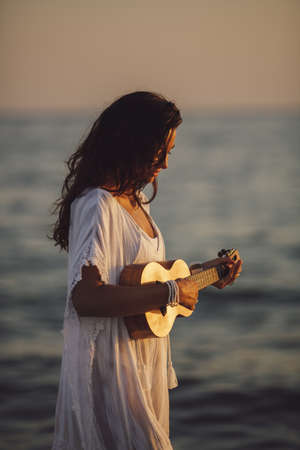 Musician Woman with Ukulele on the Beach Summer Vacationの写真素材