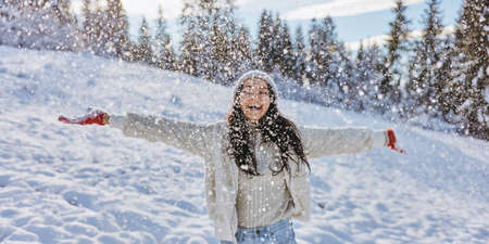 Woman in Winter Clothes Throwing Snow Outdoors in the Forest