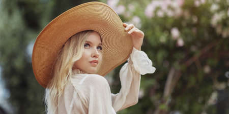 Fashion Blonde Woman in Romantic Spring Outfit in the Park. Female Womanly Beauty Portrait Outdoor on Nature.の写真素材