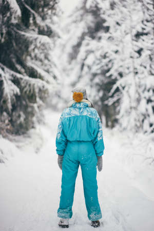Woman in ski suit in snowy forest during winter vacations outdoorsの写真素材