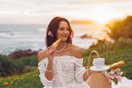 Blissful Picnic on the Beach of Romantic Girl in White Dressの写真素材