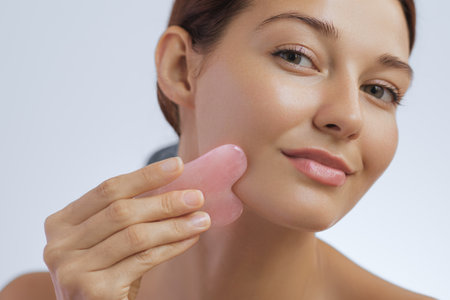 Crop of Woman Beauty and Skincare Photo with Self Face Massage Gua Sha Toolの写真素材