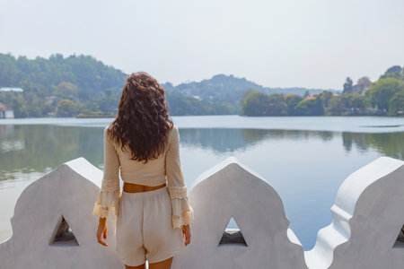 Woman Enjoying Serene Lake View in Kandy, Sri Lankaの写真素材