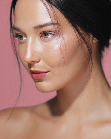 Close-Up of Womans Perfect Face with Hydrated Skin, Pink Backgroundの写真素材