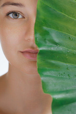 Natural Cosmetics Skin Care Beauty Portrait. Woman With Green Leaf Closeupの写真素材