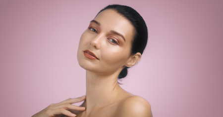 Elegant Brunette Woman with Bright Evening Makeup on Pink Backgroundの写真素材