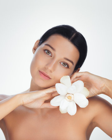 Serene Woman Holding White Lotus Flower in Minimalist Wellness Portraitの写真素材