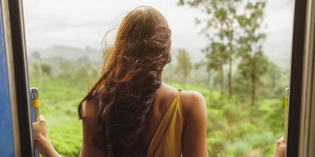 Back View of Woman in Yellow Dress Embracing Nature During Scenic Train Ride