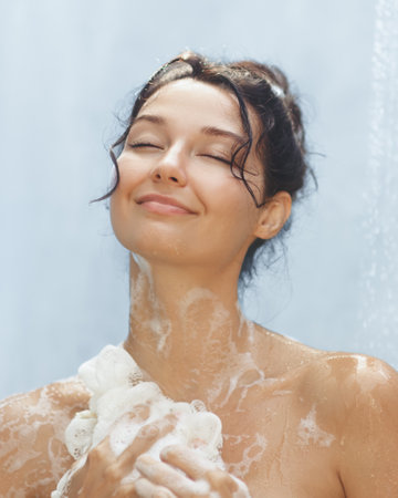 Woman Smiling Blissfully While Enjoying a Foamy Showerの写真素材